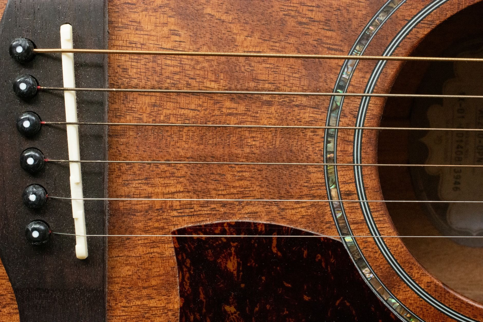 Detailed close-up of an acoustic guitar, showcasing strings and wood texture.